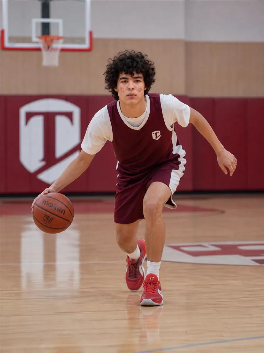 Basketbol toʻpini olib borayotgan oʻquvchi